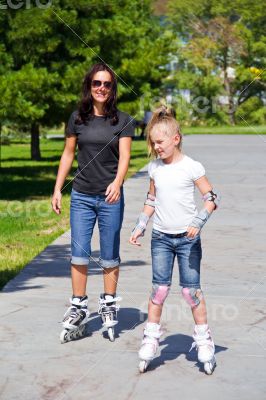 Learning mother and daughter on roller skates