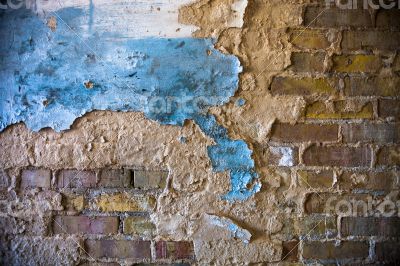 Old brick wall with the damaged plaster