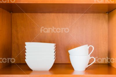 Organized minimalistic kitchen cabinet with white porcelain bowl