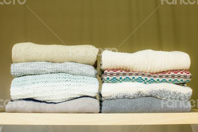Pile of warm sweaters on a shelf