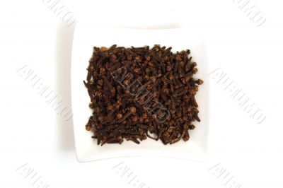 whole cloves in square white bowl isolated