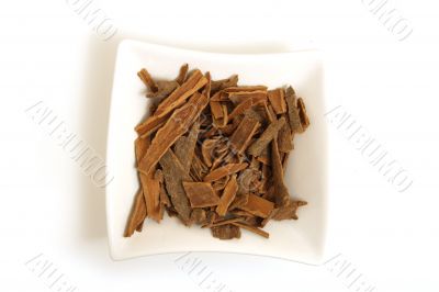 cinnamon in square white bowl isolated