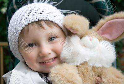 Small smiling girl with plush toy.