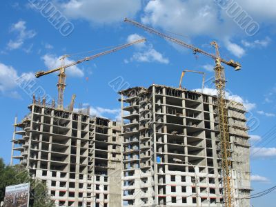 Two yellow tower cranes on a construction site