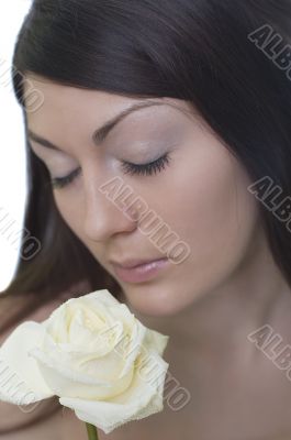 Female smells a white rose