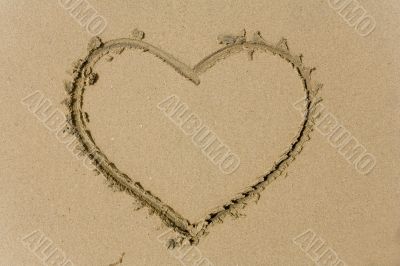 drawing heart on sea sand