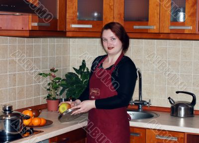 The young red woman on kitchen