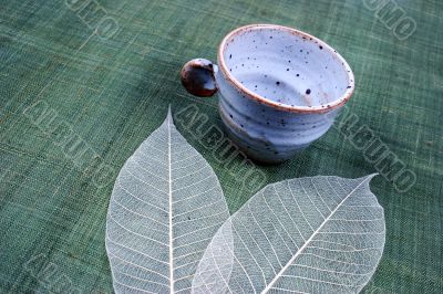 Pottery cup and pretty spring leaves