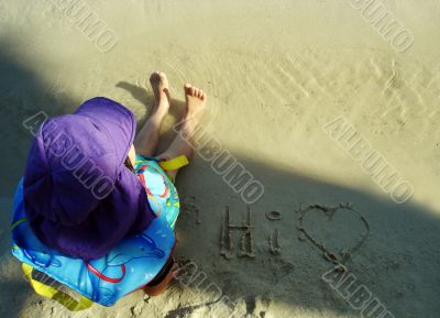 Young child sitting on the sand at the beach