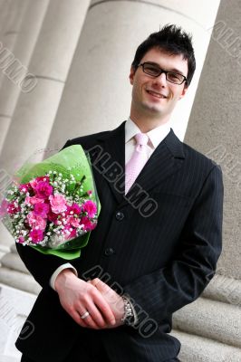 Happy man with flowers under his arm