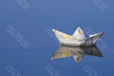 a paper boat floating in a lake