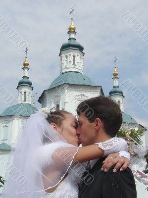 Newlyweds couple kissing upon cathedral