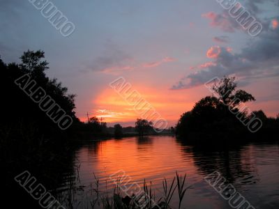 River before sunset. Trees silhouettes.