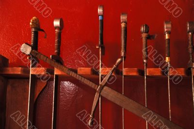 Swords against red wall.
