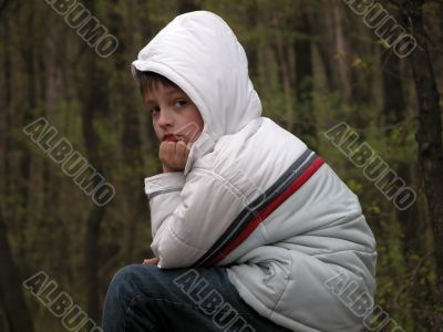Boy sitting on forest background