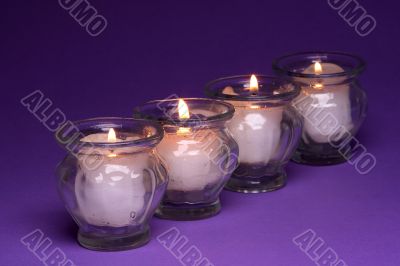 Four candles over textured paper