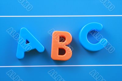 colorful letters A B C on blue board close-ups