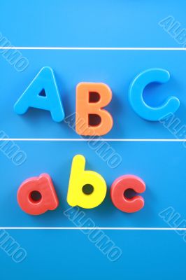 colorful letters A B C on blue board close-ups