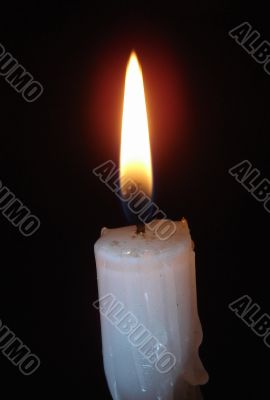 Alone candle flame upon black background