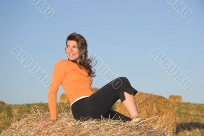 Beautiful woman in a field with hay bales