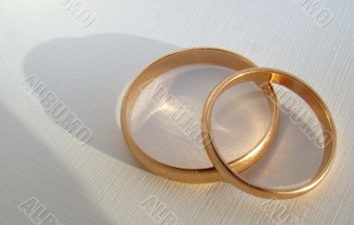 Two wedding gold rings on white background