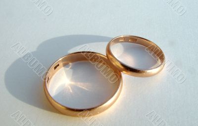 Two wedding gold rings on white background