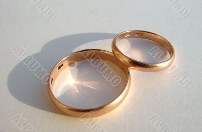 Two wedding gold rings on white background