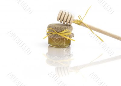 Wooden honey drizzlier and a jar of honey