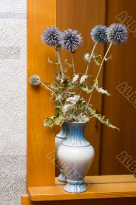 Bouquet of flowers in a vase at a mirror