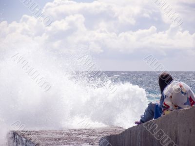  The girl sits on a coast and looks at the sea