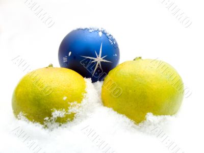 Two tangerines and a christmas sphere on snow