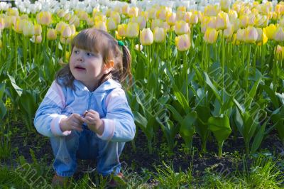 Thoughtful girl in tulips