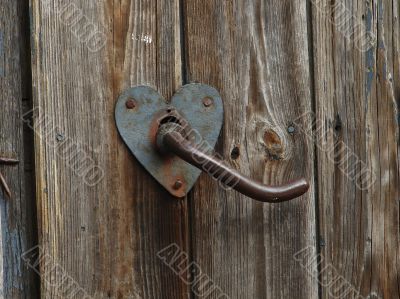 Aged door handle on wooden door