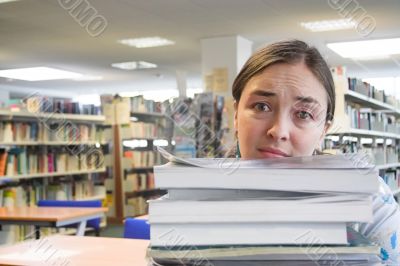 female student in a library - too much work