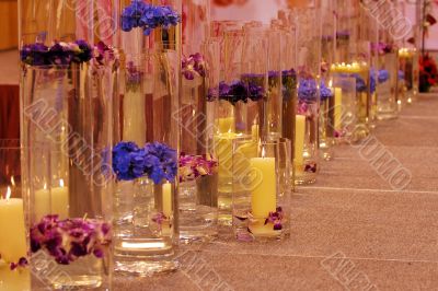 Row of different vases with flowers and candles