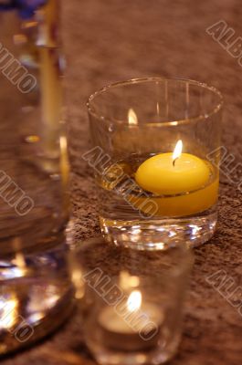 Burning candle in water glass