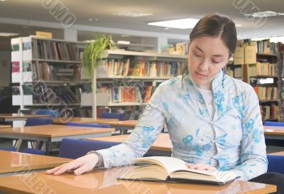 Beautiful woman reading a book in the library