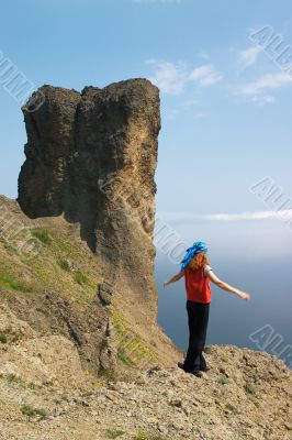 Girl on the rock above the sea