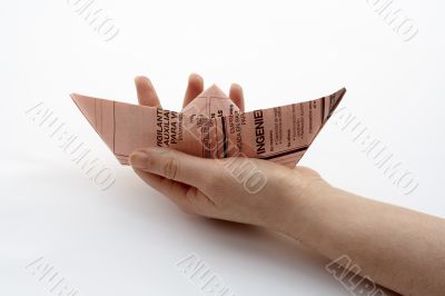 holding a paper boat