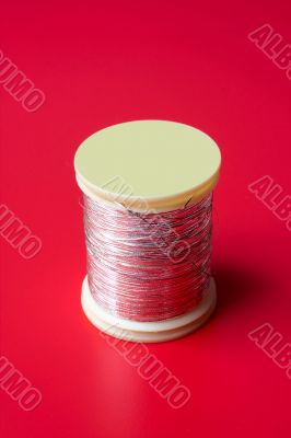 bobbin of thread on a red background