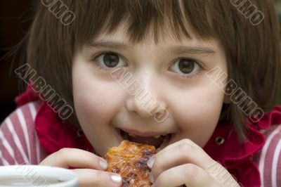 A little girl eats pizza