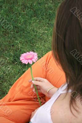 girl holding a beautiful flower from the back