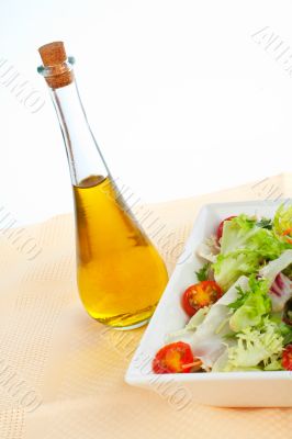 Oil bottle and green salad