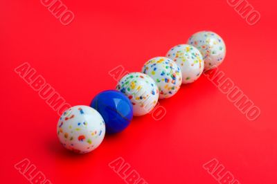 One blue ball amongst five white balls