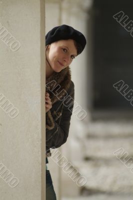 young woman leans at a pillar