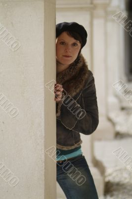 young woman leans at a pillar