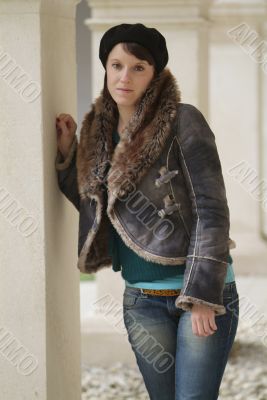 young woman leans at a pillar