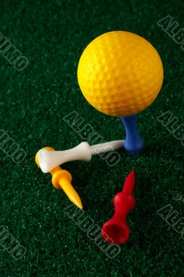 Yellow golfball and tees