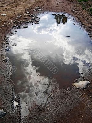 Road, water and clouds reflection