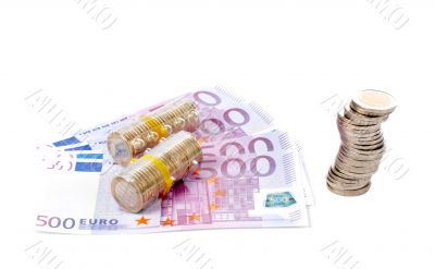 Stack of coins over a euro bills
